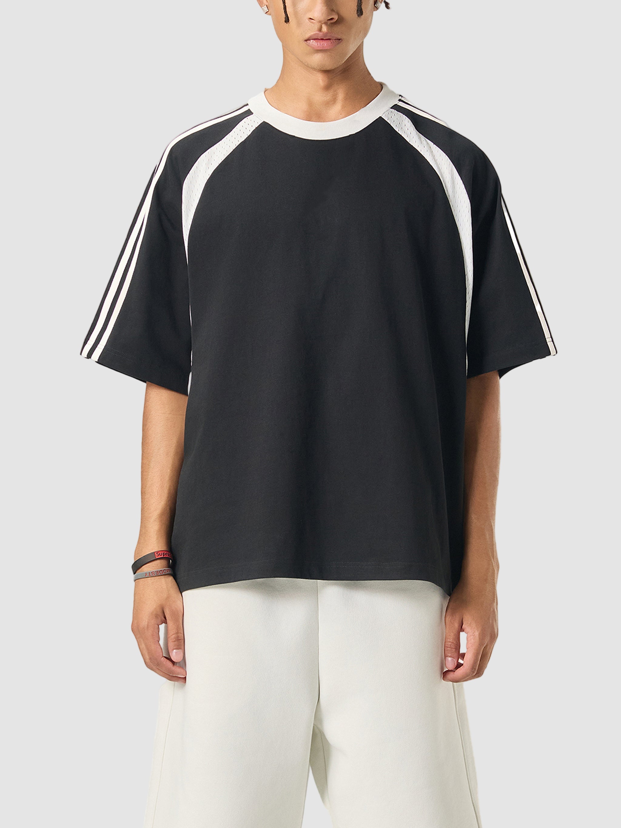 Person wearing a black t-shirt with white stripes on a white background