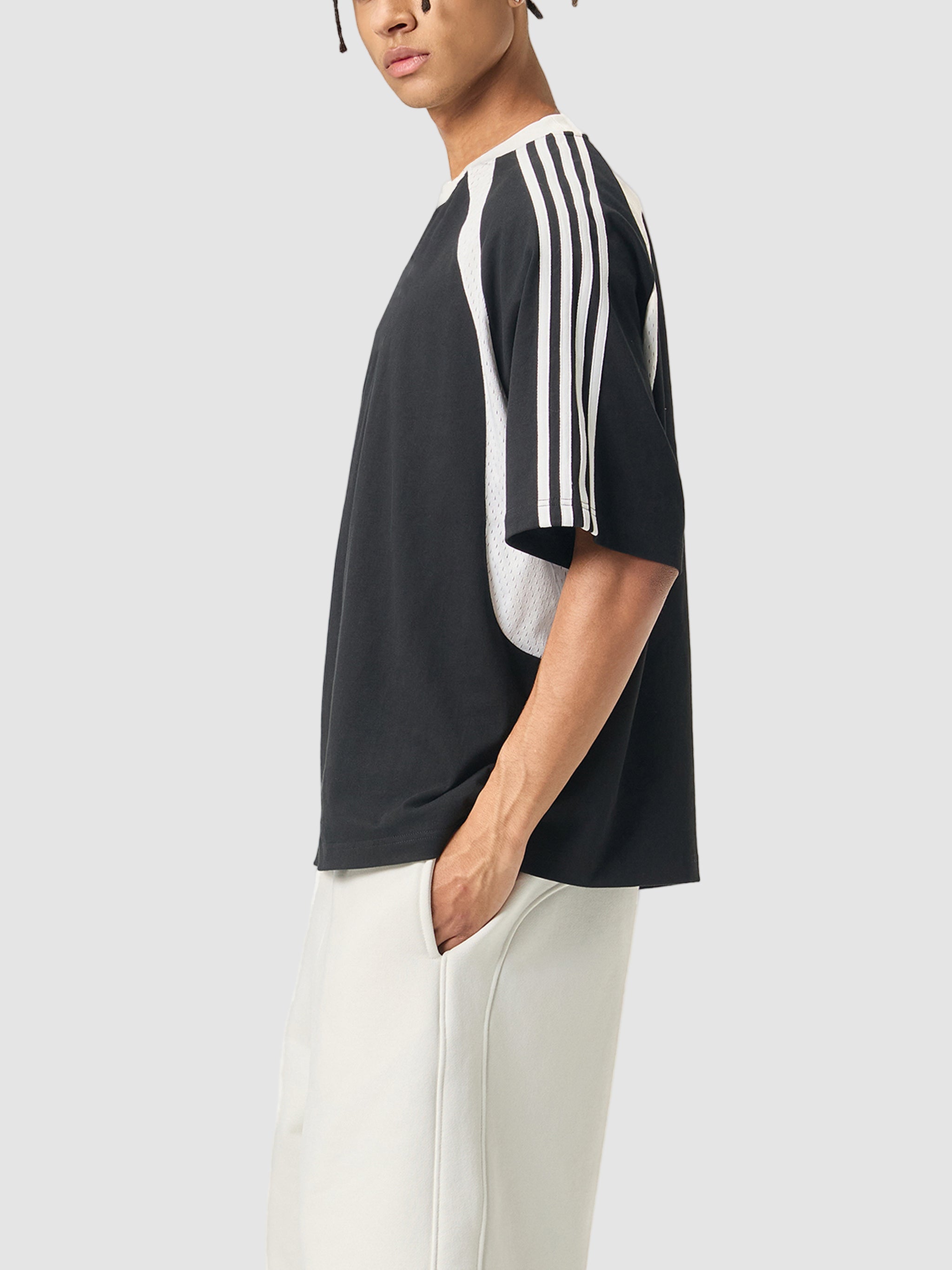 Person wearing a black and white striped shirt with a plain background
