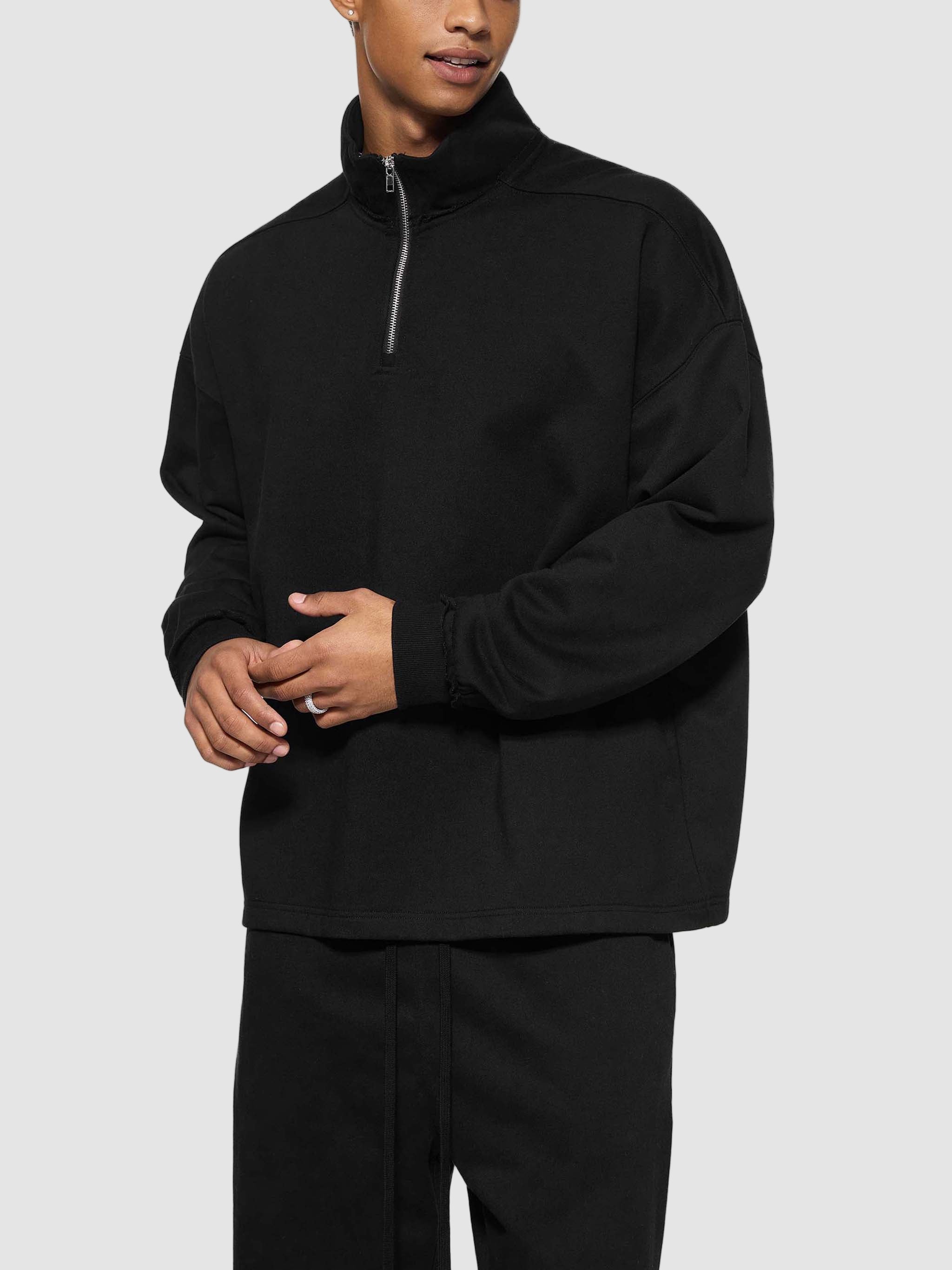 Person wearing a black quarter-zip sweatshirt on a white background