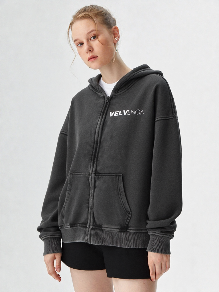 Person wearing a black hoodie with 'VELVENIA' branding on a white background