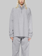 Person wearing a gray sweatshirt and pants on a white background