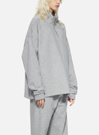 Person wearing a gray tracksuit on a white background
