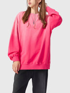 Person wearing a bright pink sweatshirt on a white background