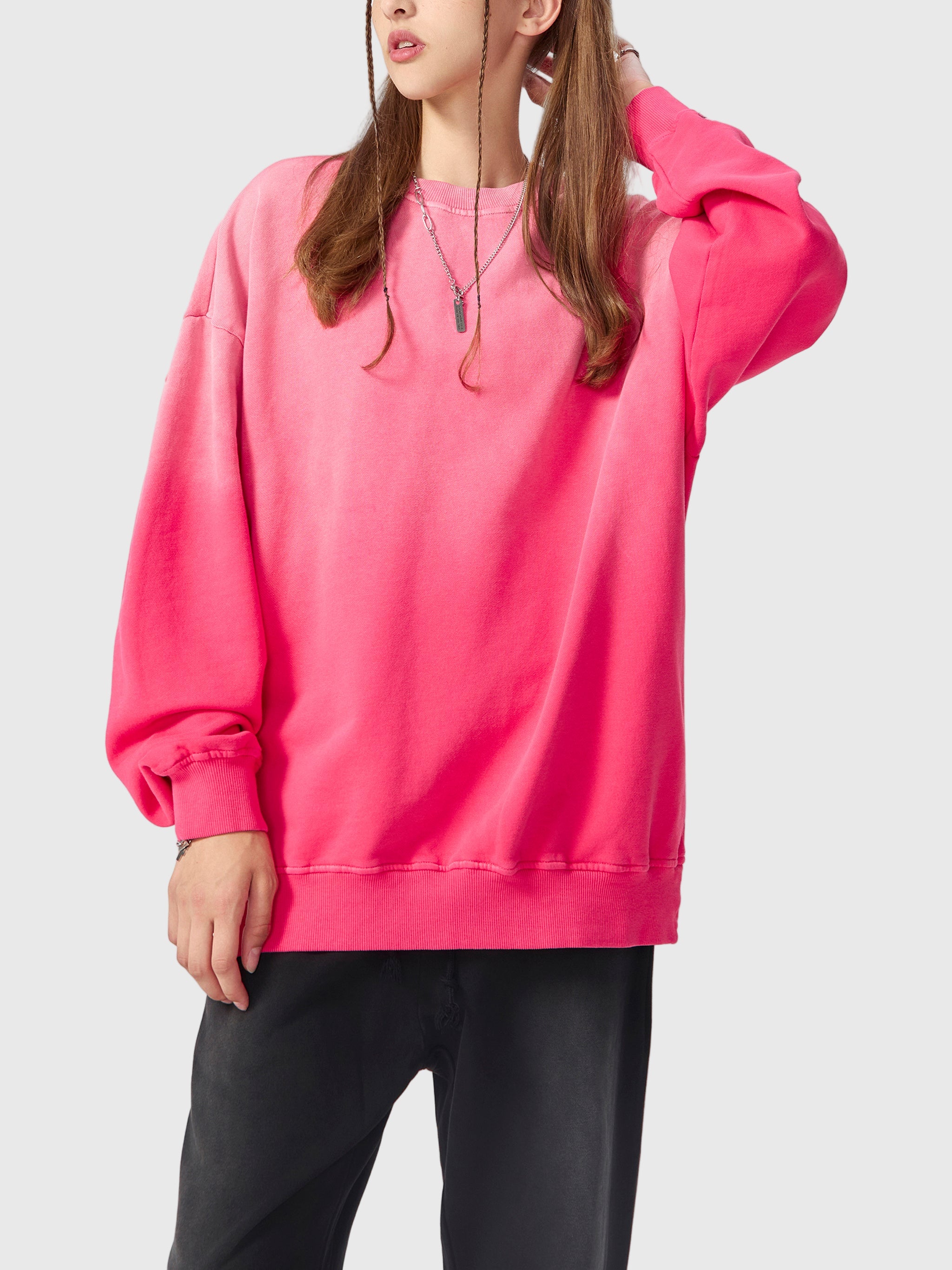 Person wearing a bright pink sweatshirt on a white background