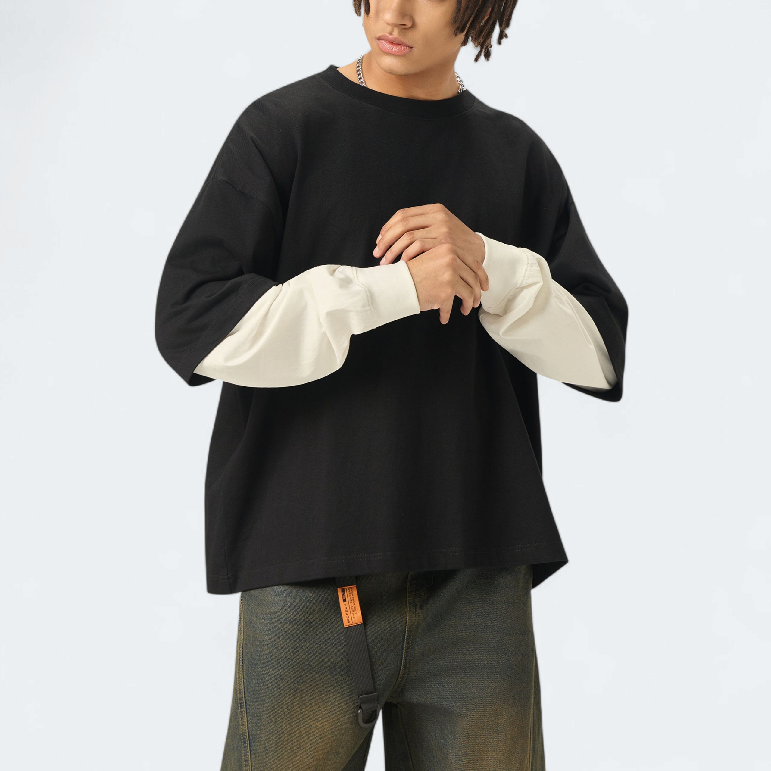 Person wearing a black and white long-sleeve shirt with a plain background