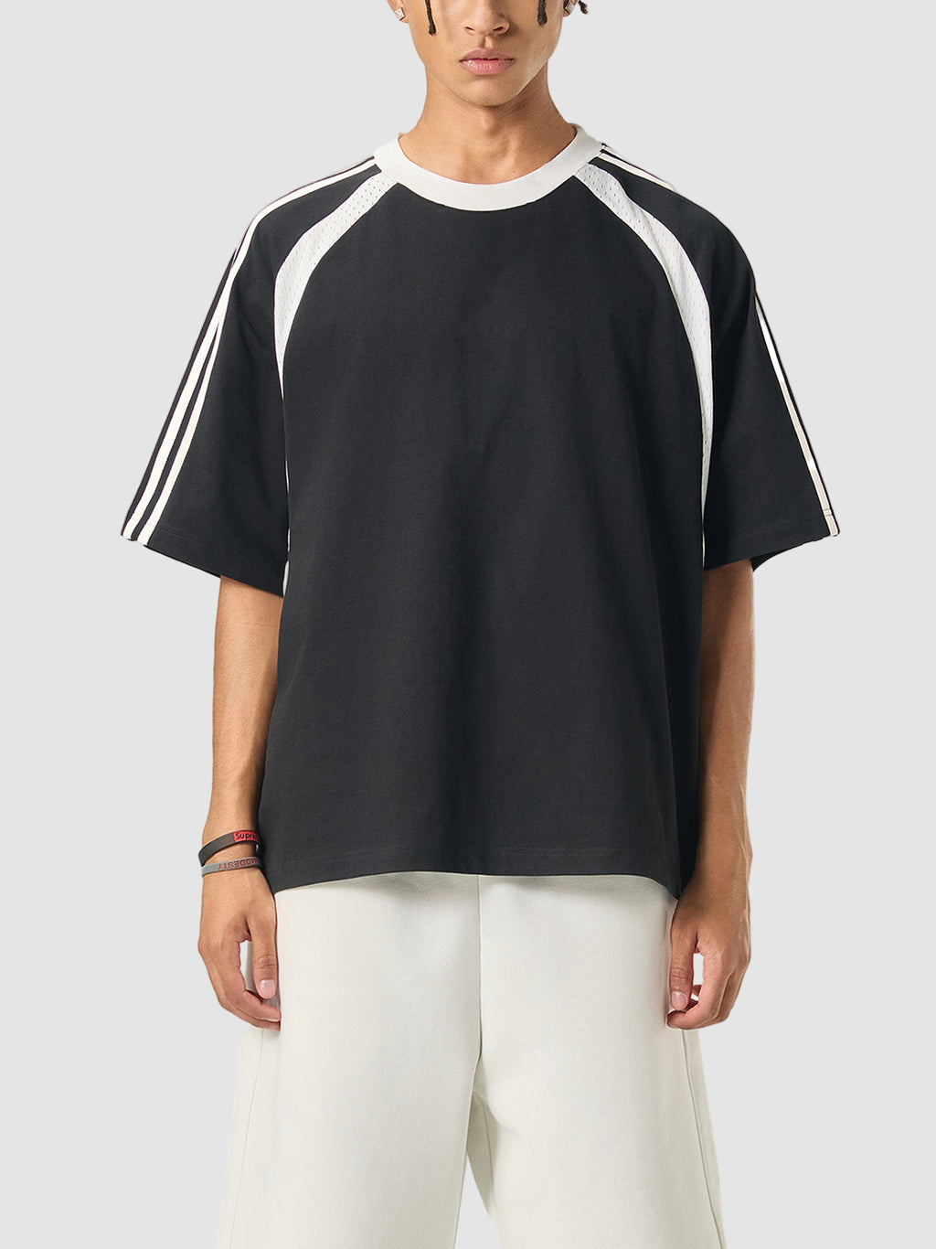 Person wearing a black t-shirt with white stripes on a white background
