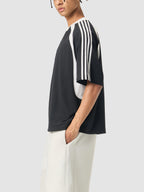 Person wearing a black and white striped shirt with a plain background