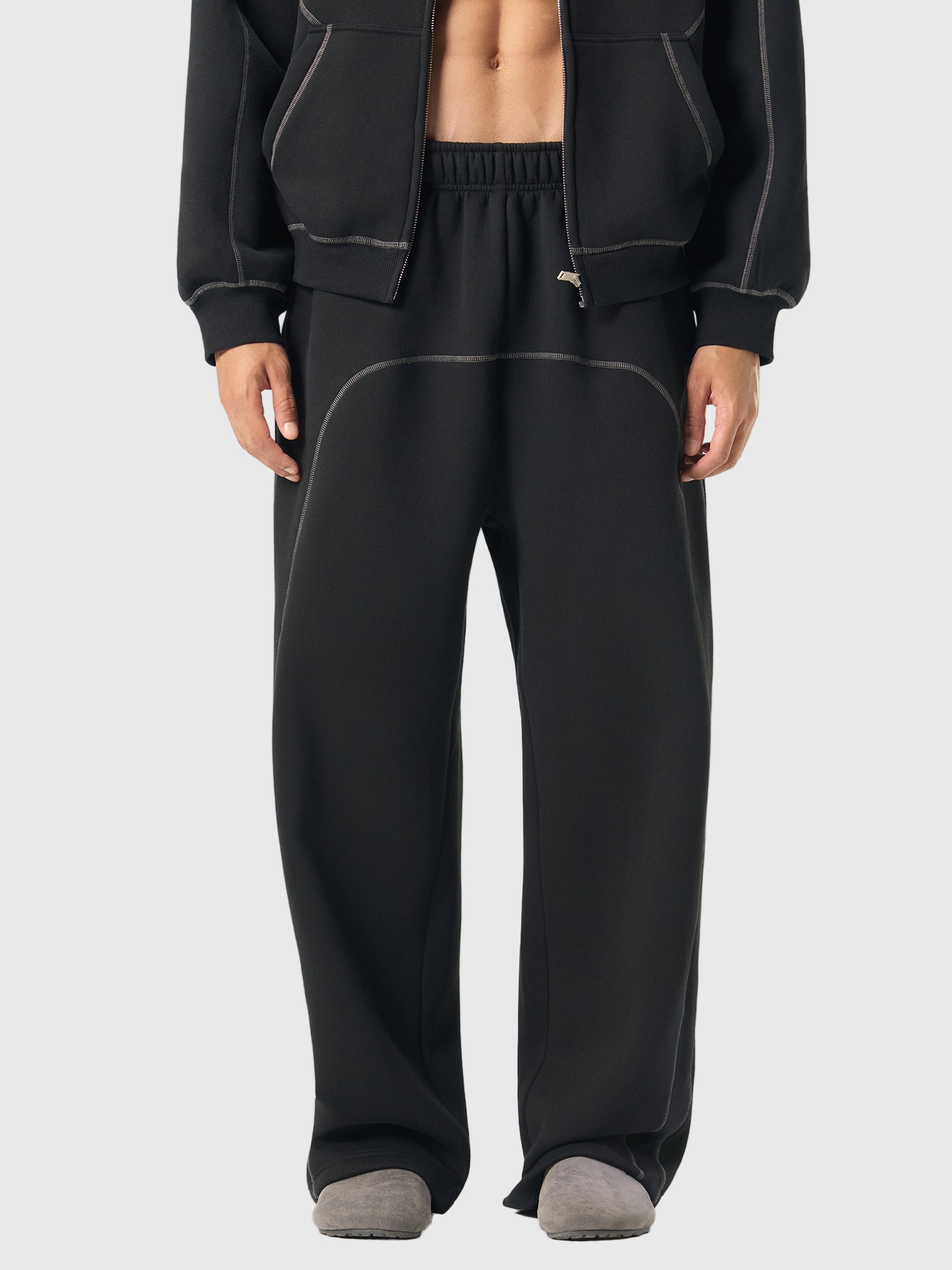 Person wearing a black tracksuit on a white background