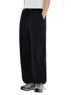 Person wearing black wide-leg pants on a white background